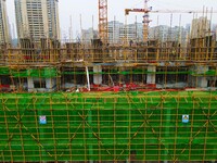 Workers are stepping up construction at the resettlement area project site in Yuexi County, Anqing City, Anhui Province, China, on December...