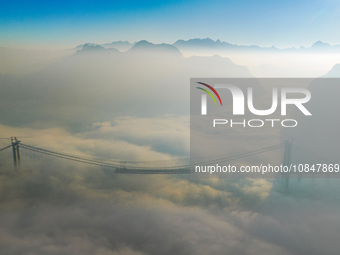 Workers are hoisting a steel girder of the main bridge in the clouds at the Zangke River Bridge on the expressway in Bijie, Guizhou Province...