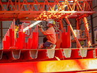 Workers are hoisting a steel girder of the main bridge in the clouds at the Zangke River Bridge on the expressway in Bijie, Guizhou Province...