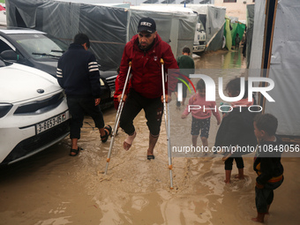 Palestinians are taking refuge amid the rain at a camp for displaced people in Deir El-Balah, in the central Gaza Strip, as battles continue...