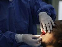 A dentist is performing tests with dental prostheses at the Centro de Odontogeriatria TIII Doctor Guillermo Roman y Carrillo Health Centre i...