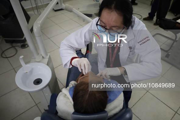 A dentist at the Centro de Salud TIII Doctor Guillermo Roman y Carrillo in the Iztapalapa district of Mexico City is attending to an older a...