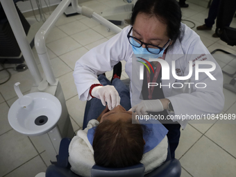 A dentist at the Centro de Salud TIII Doctor Guillermo Roman y Carrillo in the Iztapalapa district of Mexico City is attending to an older a...