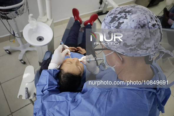 A dentist at the Centro de Salud TIII Doctor Guillermo Roman y Carrillo in the Iztapalapa district of Mexico City is attending to an older a...