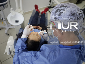 A dentist at the Centro de Salud TIII Doctor Guillermo Roman y Carrillo in the Iztapalapa district of Mexico City is attending to an older a...