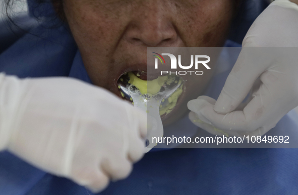 A dentist at the Centro de Salud TIII Doctor Guillermo Roman y Carrillo in the Iztapalapa district of Mexico City is attending to an older a...