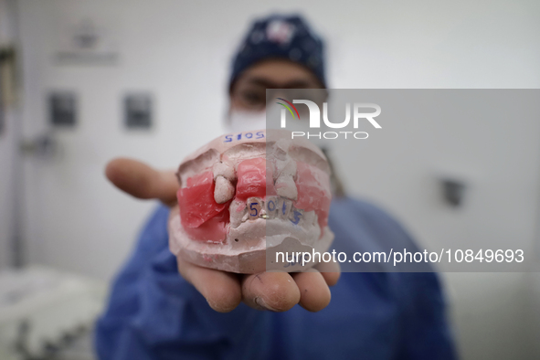 A dentist is holding a dental impression inside the Centro de Odontogeriatria Centro de Salud TIII Doctor Guillermo Roman y Carrillo in the...