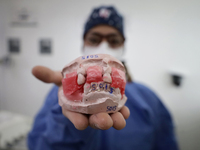 A dentist is holding a dental impression inside the Centro de Odontogeriatria Centro de Salud TIII Doctor Guillermo Roman y Carrillo in the...