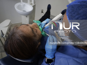 A dentist at the Centro de Salud TIII Doctor Guillermo Roman y Carrillo in the Iztapalapa district of Mexico City is attending to an older a...