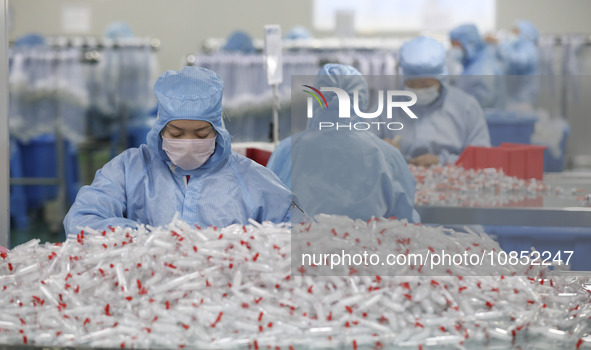 Workers are making medical infusion sets for export in a workshop in Huai'an City, Jiangsu Province, China, on December 14, 2023. 