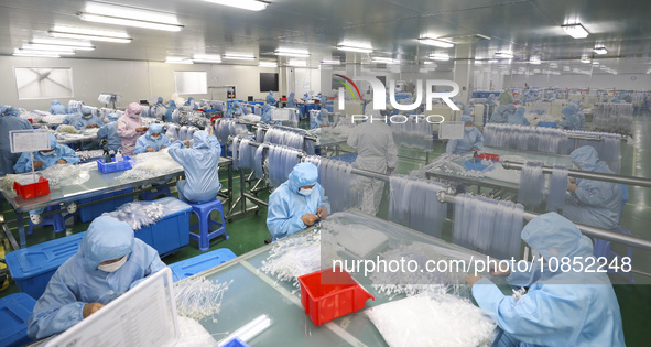 Workers are making medical infusion sets for export at a workshop in Huai'an City, Jiangsu Province, China, on December 14, 2023. 