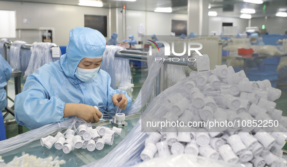 Workers are making medical infusion sets for export in a workshop in Huai'an City, Jiangsu Province, China, on December 14, 2023. 