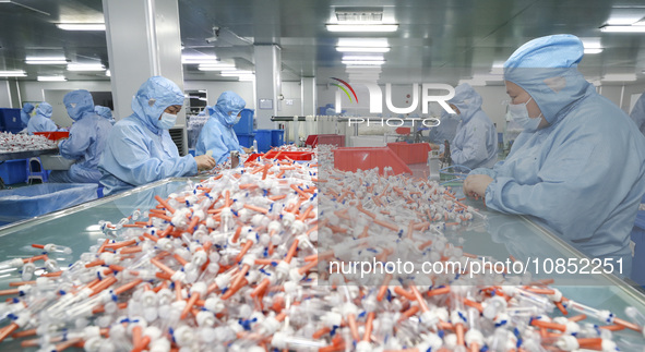 Workers are making medical infusion sets for export in a workshop in Huai'an City, Jiangsu Province, China, on December 14, 2023. 