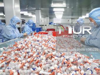 Workers are making medical infusion sets for export in a workshop in Huai'an City, Jiangsu Province, China, on December 14, 2023. (