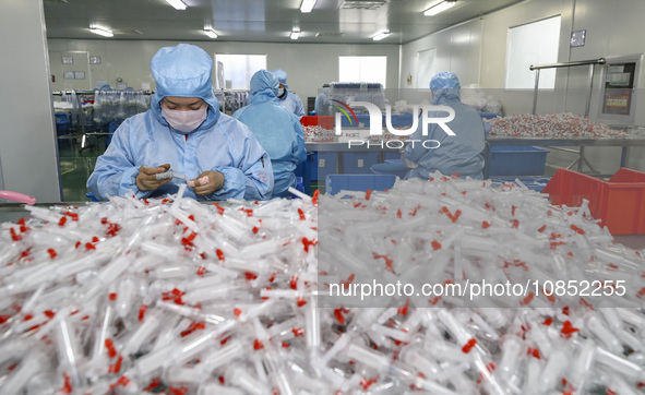 Workers are making medical infusion sets for export at a workshop in Huai'an City, Jiangsu Province, China, on December 14, 2023. 