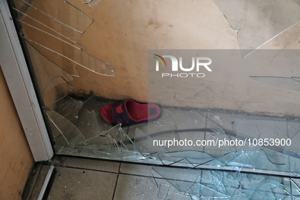 A slipper is seen behind a broken window in a hostel that is being damaged in a Russian overnight attack in Odesa, southern Ukraine, on Dece...