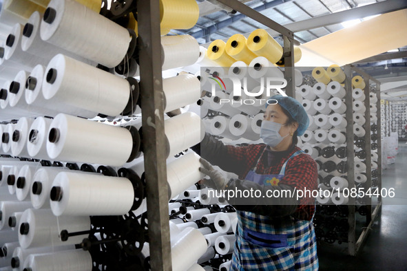 A worker is rushing to complete an order at a woven bag production workshop in Lianyungang, Jiangsu Province, China, on December 15, 2023. 