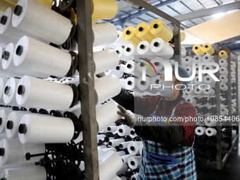 A worker is rushing to complete an order at a woven bag production workshop in Lianyungang, Jiangsu Province, China, on December 15, 2023. (