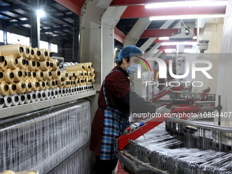 A worker is rushing to complete an order at a woven bag production workshop in Lianyungang, Jiangsu Province, China, on December 15, 2023. (