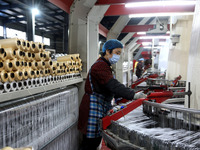 A worker is rushing to complete an order at a woven bag production workshop in Lianyungang, Jiangsu Province, China, on December 15, 2023. (