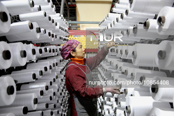 A worker is rushing to complete an order at a woven bag production workshop in Lianyungang, Jiangsu Province, China, on December 15, 2023. 