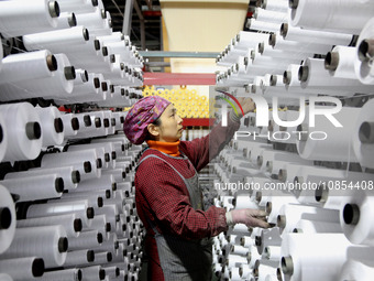 A worker is rushing to complete an order at a woven bag production workshop in Lianyungang, Jiangsu Province, China, on December 15, 2023. (