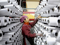 A worker is rushing to complete an order at a woven bag production workshop in Lianyungang, Jiangsu Province, China, on December 15, 2023. (