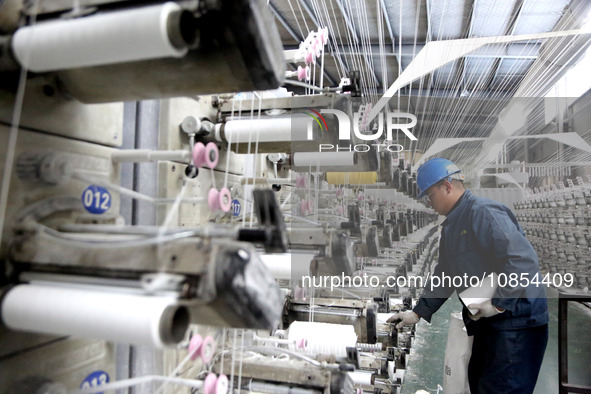 A worker is rushing to complete an order at a woven bag production workshop in Lianyungang, Jiangsu Province, China, on December 15, 2023. 