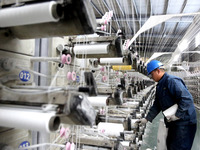 A worker is rushing to complete an order at a woven bag production workshop in Lianyungang, Jiangsu Province, China, on December 15, 2023. (