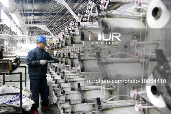 A worker is rushing to complete an order at a woven bag production workshop in Lianyungang, Jiangsu Province, China, on December 15, 2023. 