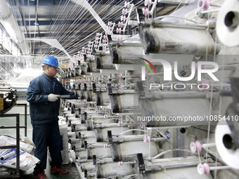 A worker is rushing to complete an order at a woven bag production workshop in Lianyungang, Jiangsu Province, China, on December 15, 2023. (