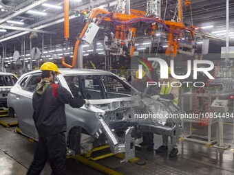 A worker is working at the production workshop of Great Wall Motor's Taizhou Smart Factory in Taizhou, Jiangsu Province, China, on December...