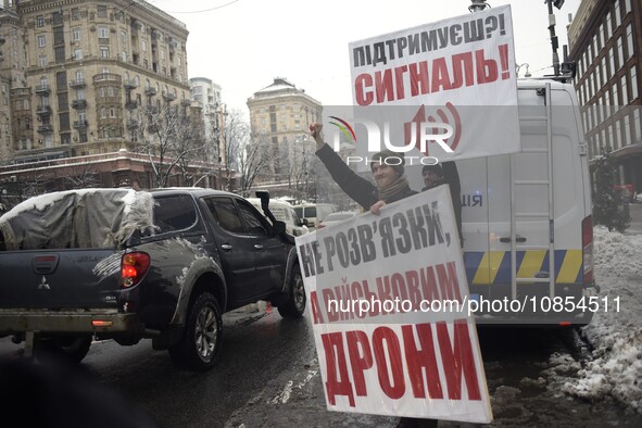 Demonstrators are holding placards as they demand an increase in financial support for the Armed Forces of Ukraine outside the Kyiv City Sta...