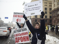 Demonstrators are holding placards as they demand an increase in financial support for the Armed Forces of Ukraine outside the Kyiv City Sta...