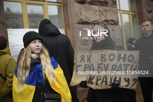 Demonstrators are holding placards as they demand an increase in financial support for the Armed Forces of Ukraine outside the Kyiv City Sta...