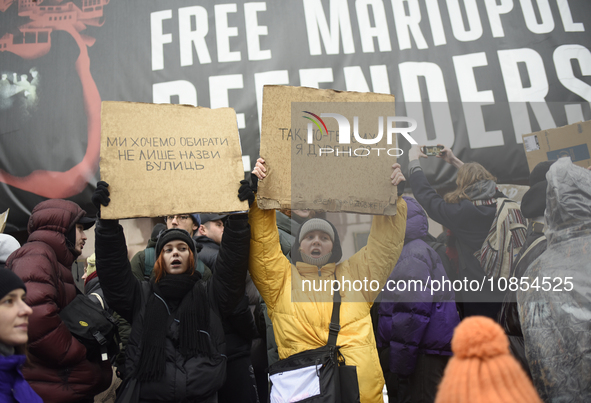 Demonstrators are holding placards as they demand an increase in financial support for the Armed Forces of Ukraine outside the Kyiv City Sta...