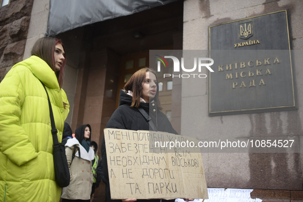 Demonstrators are holding placards as they demand an increase in financial support for the Armed Forces of Ukraine outside the Kyiv City Sta...