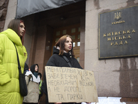 Demonstrators are holding placards as they demand an increase in financial support for the Armed Forces of Ukraine outside the Kyiv City Sta...