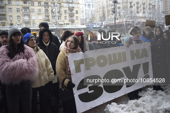 Demonstrators are holding placards as they demand an increase in financial support for the Armed Forces of Ukraine outside the Kyiv City Sta...