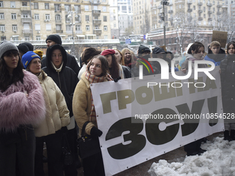 Demonstrators are holding placards as they demand an increase in financial support for the Armed Forces of Ukraine outside the Kyiv City Sta...