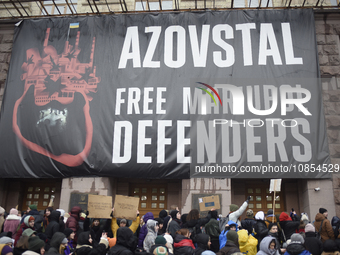 Demonstrators are holding placards as they demand an increase in financial support for the Armed Forces of Ukraine outside the Kyiv City Sta...