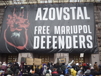 Demonstrators are holding placards as they demand an increase in financial support for the Armed Forces of Ukraine outside the Kyiv City Sta...