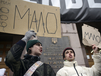 Demonstrators are holding placards as they demand an increase in financial support for the Armed Forces of Ukraine outside the Kyiv City Sta...