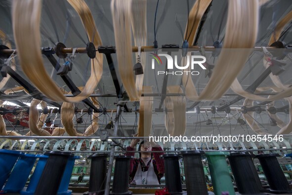 A worker is working at a workshop of a textile company in Haian, Jiangsu Province, East China, on December 14, 2023. 