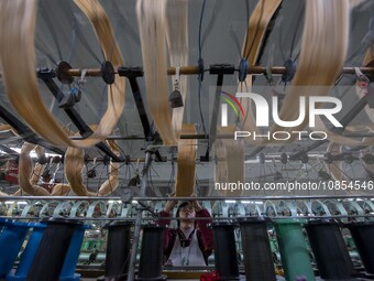 A worker is working at a workshop of a textile company in Haian, Jiangsu Province, East China, on December 14, 2023. (