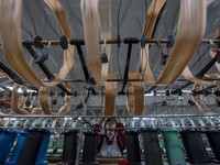 A worker is working at a workshop of a textile company in Haian, Jiangsu Province, East China, on December 14, 2023. (