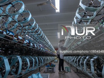 A worker is working at a workshop of a textile company in Haian, Jiangsu Province, East China, on December 14, 2023. (