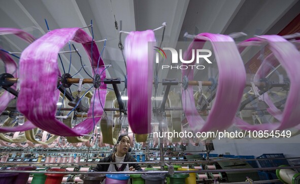 A worker is working at a workshop of a textile company in Haian, Jiangsu Province, East China, on December 14, 2023. 