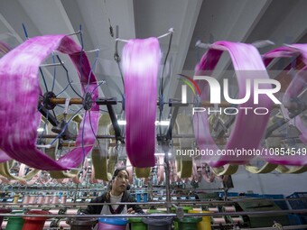 A worker is working at a workshop of a textile company in Haian, Jiangsu Province, East China, on December 14, 2023. (