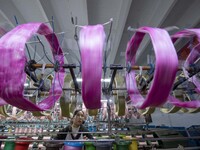 A worker is working at a workshop of a textile company in Haian, Jiangsu Province, East China, on December 14, 2023. (